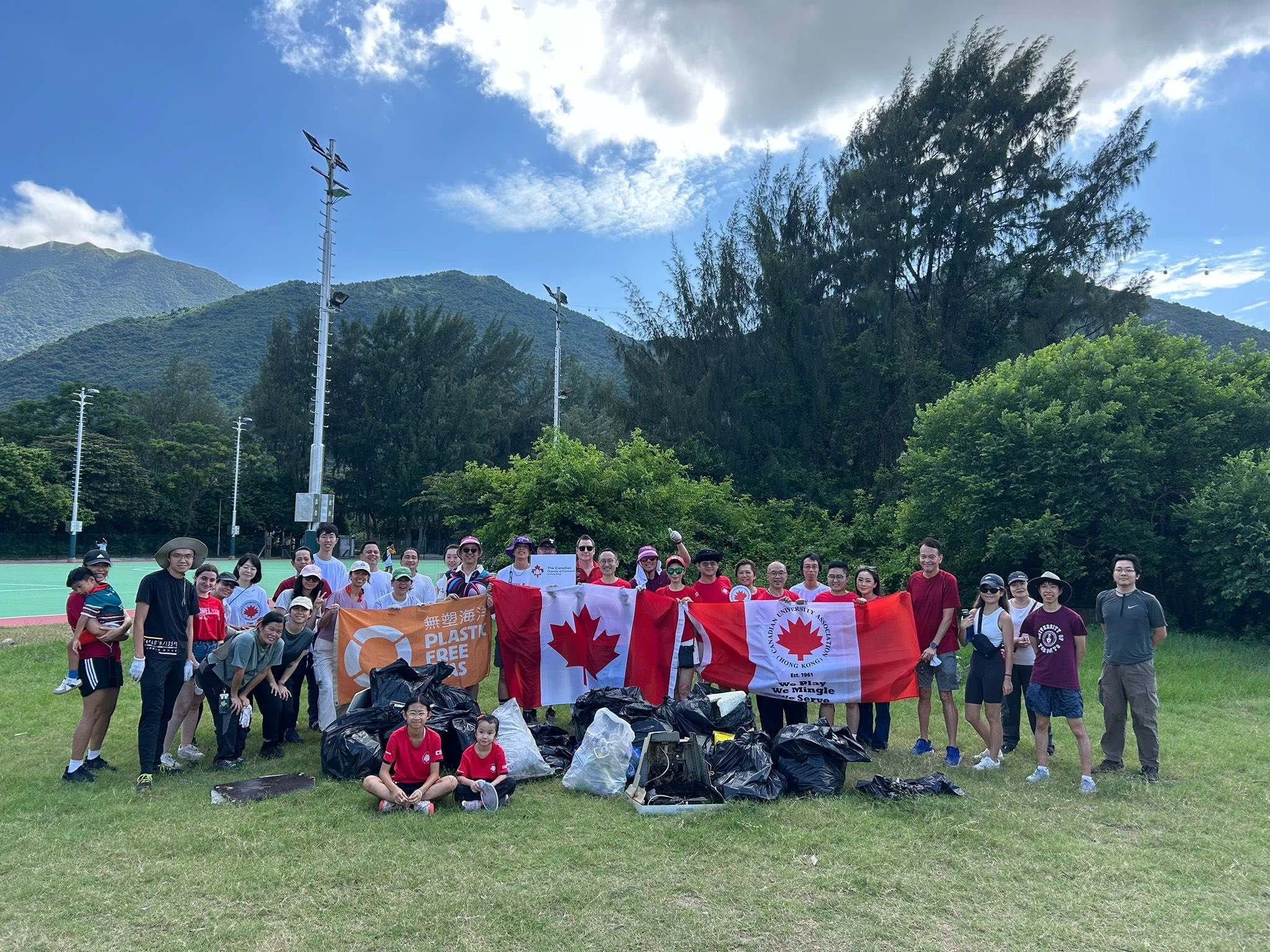 Chamber members at a Hong Kong beach clean-up, holding the Canadian flag